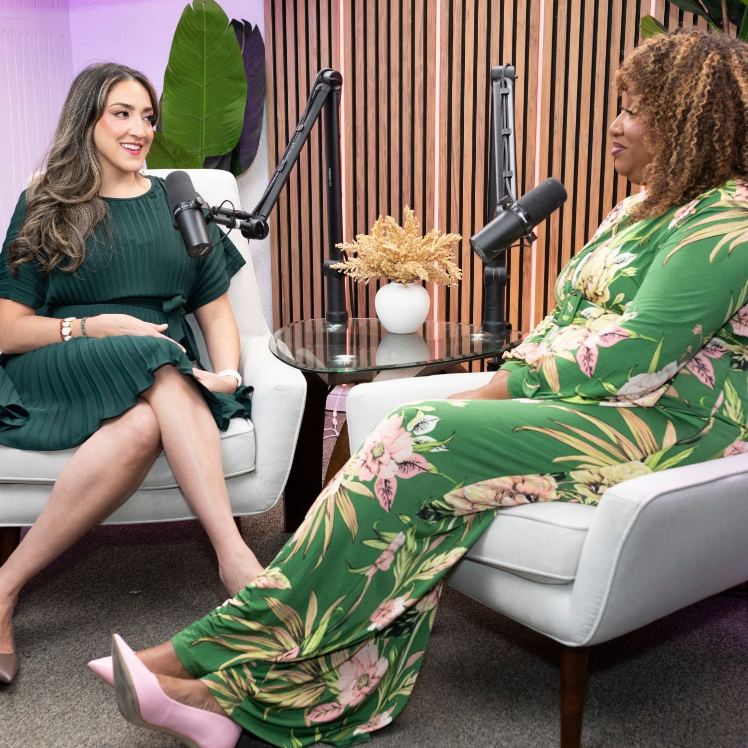 Shana & Kisha wearing green sitting in white chairs with microphones in front of them